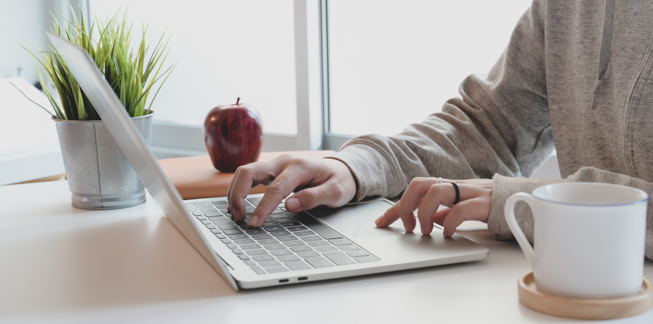 Person in Gray Long Sleeve Top Using Mac-book Pro